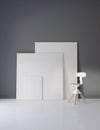 Pictures and chair in gray studio with atmospheric lighting
