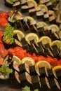 Pictures of fresh sushi dishes with a large variety decorated with lemon and colorful ginger with lettuce leaves. Selective focus