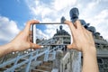 Pictures on mobile smart phone in Front View of Tian Tan Giant Buddha in blue sky