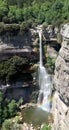 Panoramic view of 115m high waterfall of Salt de Sallent, with tiny rainbow.