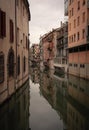 Picturesque alleyway with colorful buildings and a canal running through it in Padova, Italy