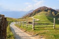 Picturesque Alps autumn landscape, wooden fence and mountain hills in Lombardy, Italy. Tourist adventure Royalty Free Stock Photo