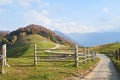 Picturesque Alps autumn landscape, wooden fence and mountain hills in Lombardy, Italy. Royalty Free Stock Photo