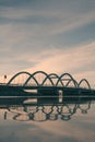 Picturesque arched bridge spanning a tranquil body of water at sunset