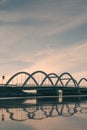 Picturesque arched bridge spanning a tranquil body of water at sunset