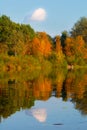 Picturesque autumn landscape of river and bright trees, cloud at the sky