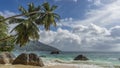 A picturesque beach on a tropical island. Granite boulders are scattered in the turquoise ocean, on the sand. Royalty Free Stock Photo