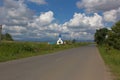 Picturesque beautiful contryside road with white and blue church on the left