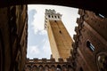 Picturesque bottom view of Torre del Mangia (Mangia tower) from inside of Palazzo Publico inner courtyard in Siena, Tuscany, Italy Royalty Free Stock Photo