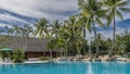 Picturesque boulders and coconut palms grow on the shore of the aquamarine swimming pool. Royalty Free Stock Photo