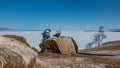 Picturesque boulders lie on the ground, on the shore of a frozen lake.