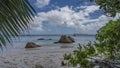 Picturesque boulders and rocks rise in the turquoise ocean.