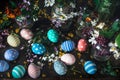 Picturesque bouquets of colorful spring flowers in glass vases bottles and colorful handmade paint easter eggs on a dark wooden Royalty Free Stock Photo