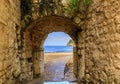 Picturesque brick arch and path of the medieval Old town open onto the Adriatic Sea in the Balkans in Budva, Montenegro Royalty Free Stock Photo