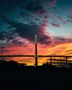 a bridge going across a river with a sunset in the background Royalty Free Stock Photo