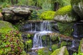 A picturesque cascade waterfall among large moss covered stones in the landscape Sophia Park, Uman, Ukraine, Autumn