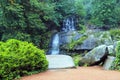 A picturesque cascade waterfall among large moss covered stones in the landscape Sophia Park, Uman, Ukraine