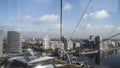 Picturesque city view from inside of teleferic cabin. Action. Landscape of a modern city buildings and the river, moving