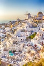 Picturesque Cityscape of Oia Village in Santorini Island Located on Red Volcanic Calderra at Daytime with Windmills on Background