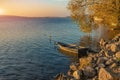 Picturesque colorful autumn landscape calm water rocky coast line of country side lake with empty lonely wooden boat September Royalty Free Stock Photo