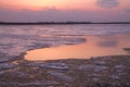 Picturesque colorful ice drift on a calm wide river during the pink sunset