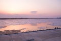 Picturesque colorful ice drift on a calm wide river during the pink sunset