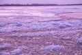 Picturesque colorful ice drift on a calm wide river during the pink sunset