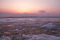 Picturesque colorful ice drift on a calm wide river during the pink sunset