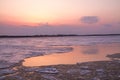 Picturesque colorful ice drift on a calm wide river during the pink sunset with pink reflection on water