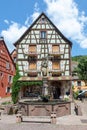 picturesque colorful street of half-timber buildings with fountain in front in the village of Kaysersberg in Vosges region