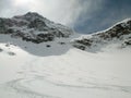 Picturesque deep winter mountain landscape in the Alps of Switzerland with backcountry ski tracks in fresh powder