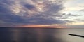 Picturesque disturbing natural background. Sunset seascape. Contrast of light sky and dark clouds. Silhouettes of people on a ston