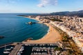 Drone view of coastal Spanish town of Blanes overlooking port, sandy beach and Sa Palomera Rock Royalty Free Stock Photo