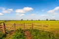 Picturesque Dutch polder landscape with wooden gate in foreground Royalty Free Stock Photo