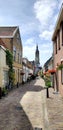Picturesque dutch street with cathedral steeple and brick walk way. Royalty Free Stock Photo