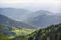 Picturesque European landscape in the mountains of the Schwarzwald, with a valley, villages, a mixed forest and rays of