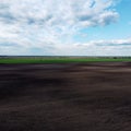 Picturesque farmland, aerial view. Beautiful sky over a plowed field