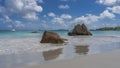 Picturesque granite cliffs on a tropical beach are washed by the waves of the ocean. Royalty Free Stock Photo