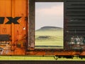 The picturesque green Texas Panhandle plateau is seen through the open doors of a rail car in morning light.