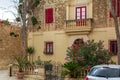 House in Mdina with red door and windows` shutters, and with lush Nerium oleander bush Royalty Free Stock Photo