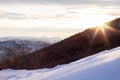 Picturesque landscape in the Altai mountains with snow-capped peaks under a blue sky with clouds and shining sun in a winter sunse Royalty Free Stock Photo