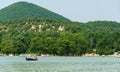 Picturesque landscape with an emerald Cypress Lake and Caucasian mountains. People ride pedal catamarans and boats Royalty Free Stock Photo