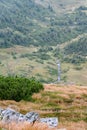 Picturesque landscape with green mountains and grassy meadow in the valley surrounded by coniferous forest on the hills Royalty Free Stock Photo