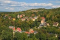 Picturesque landscape photo of Loket town. Colored residential houses on the slope of the mountain with ancient trees Royalty Free Stock Photo