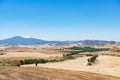 Picturesque landscape road among filds with cypress, forest, mountain and deep blue sky Royalty Free Stock Photo