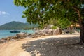 Picturesque landscape of tropical sandy Sairee beach and shade of tree and rocks