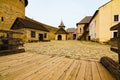 Picturesque landscape view of courtyard with ancient stone buildings in the old medieval castle. High stone wall background Royalty Free Stock Photo