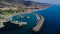 a marina with several sail boats and rocky shores on a clear day