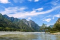 Picturesque mountain landscape on sunny summer day. River and rocky mountains against a blue sky. Pine tree stands in the water on Royalty Free Stock Photo