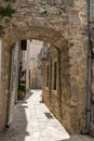 Picturesque narrow street in old town of Budva, Montenegro. Ancient houses. Stone arch inside the fortress
